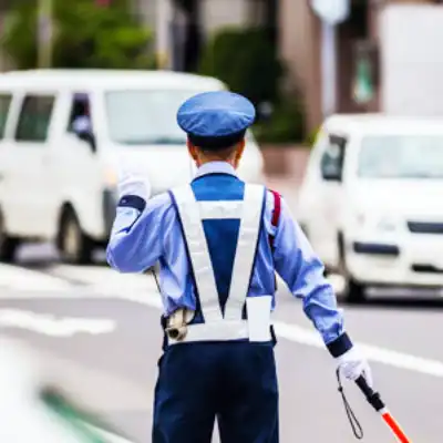 猛暑の中、警備員が水冷服を着用し業務にあたる
